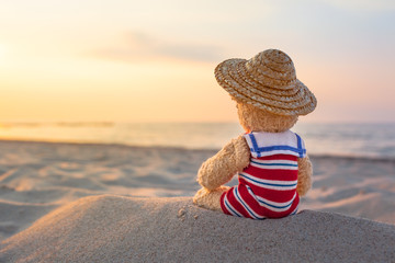 Little Cutie at Beach Holiday / Rear view of little teddy bear, wear nostalgic striped swimsuit and...