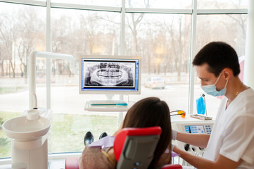 The dentist tells the patient about the condition of the teeth.