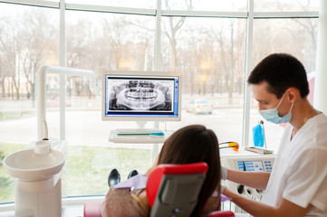 Obraz premium The dentist tells the patient about the condition of the teeth.