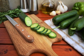 Cucumber sliced on the cutting board, kitchen table.
