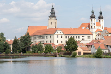 Naklejka na ściany i meble Telc, Czech Republic - August 18, 2017: panoramic view of the church of St. James and the tower of the castle reflected in the pond that surrounds them