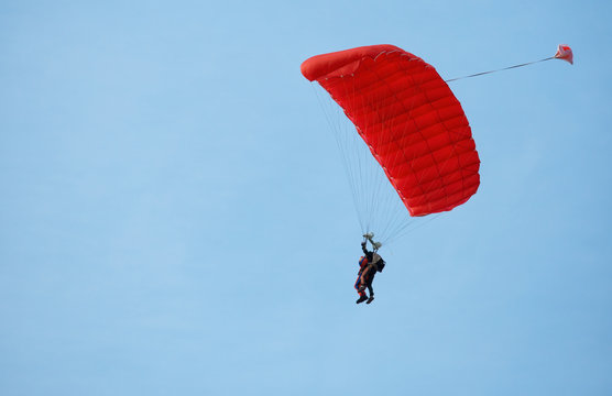 Paratrooper instructor with pupil in the sky under red dome