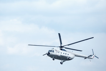 Fototapeta na wymiar White helicopter in the blue sky