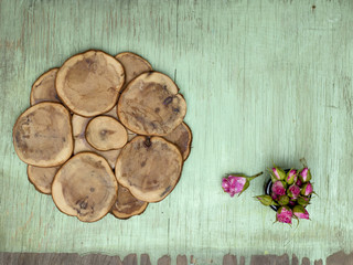 Wooden background with little pink roses. Grunge mockup. Green old painted texture.