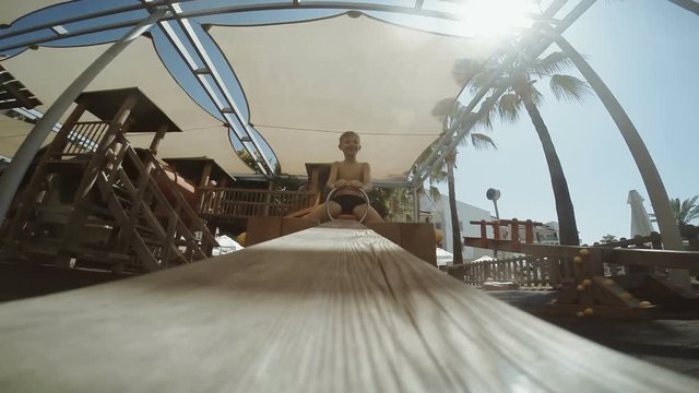 Boy having fun while riding teeter totter on playground in hotel.