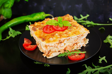 Classic Lasagna with bolognese sauce on dark background