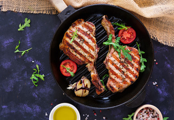 Raw pork steak with herbs on dark background. Raw juicy steak on bone. Top view