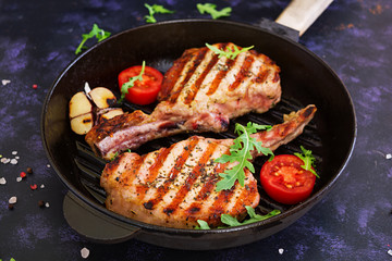 Raw pork steak with herbs on dark background. Raw juicy steak on bone