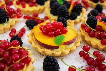 Tartlets with different berries on white background