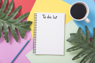 above blank to do list notebook with leaf and coffee cup on color design background.