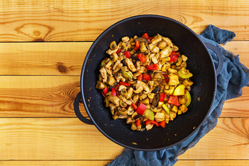 Stir fry chicken, zucchini and pepper in wok