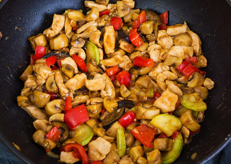 Stir fry chicken, zucchini and pepper in wok