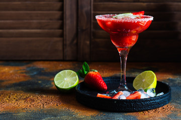Strawberry cocktail with lime and ice cubes. Space for text. Top view
