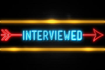 Obraz premium Interviewed - fluorescent Neon Sign on brickwall Front view