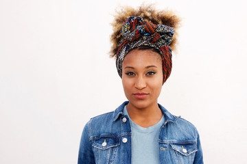 Young black woman in headscarf standing against white background