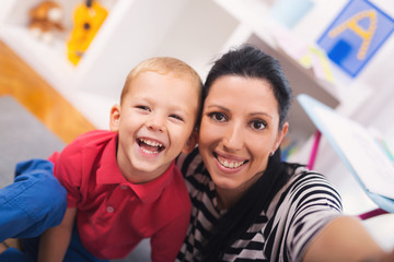 Mother with child photoshooting on smartphone selfie in the home room