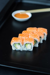 Sushi Rolls with Salmon, Cucumber and Philadelphia Cheese on Black Background, Vertical View