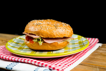 Bagel with fresh cheese and fresh lettuce on napkin