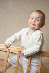 A child stands in the crib and crying