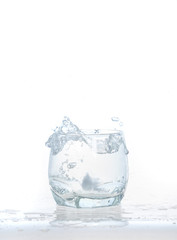 cool water, Ice cubes splashing into glass of water, water splashing from ice cubes being dropped in a glass.