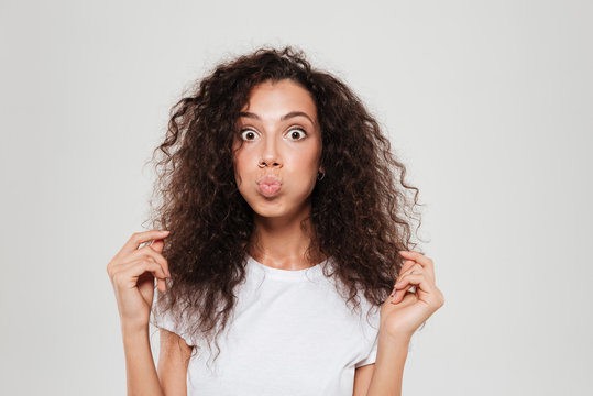 Funny Curly Woman With Inflated Cheeks Looking At The Camera