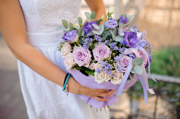 Stylish beautiful bride holds a wedding bouquet in hands