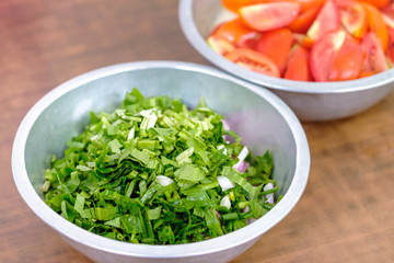 Cutting parsley with tomato background