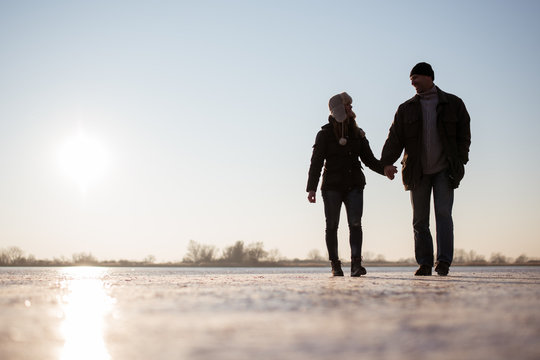 Couple talking a walk over frozen lake
