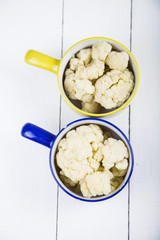 Boiled cauliflower in multi-colored bowls