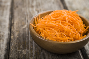 Grate  carrots in a bowl