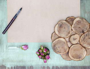 Wooden background with little pink roses. Grunge mockup. Green old painted texture. Craft paper surface.