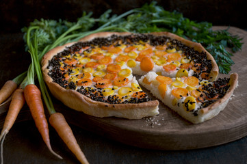 Rustic pie with carrots. On a dark background.
