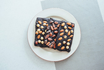 Dark chocolate, isolated on white with whole nuts.
