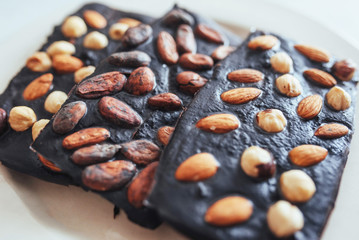 Dark chocolate, isolated on white with whole nuts.