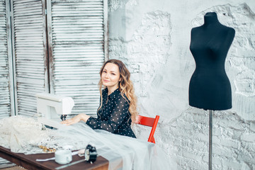 seamstress sews clothes. tailor woman threading needle of sewing machine