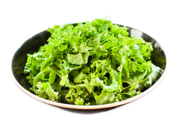 Fresh green kale salad leaves in a bowl isolated on white  with copy space for text background.