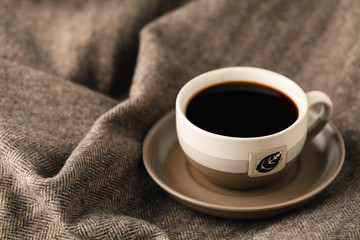 selective focus photo of cozy knitted scarf with to cup of coffee and open book. style retro filtered