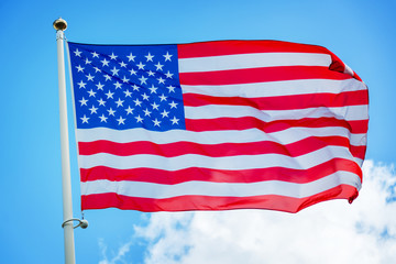 American US flag on a pole against blue sky