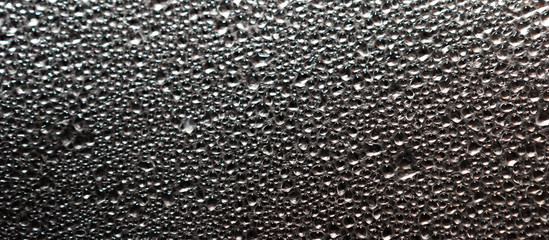 Abstract background of wet steam or water droplets on aluminum foil surface. Macro top view.