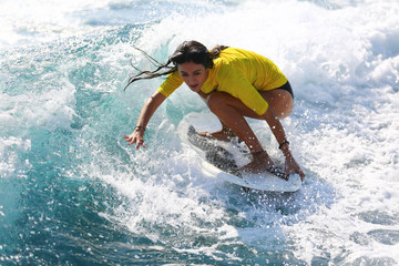 Young girl surfing on the waves.