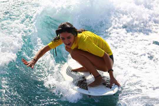 Young girl surfing on the waves.