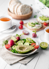 Flatbread with avocado and raddish, cup of tea