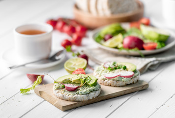 Flatbread with avocado and raddish, cup of tea