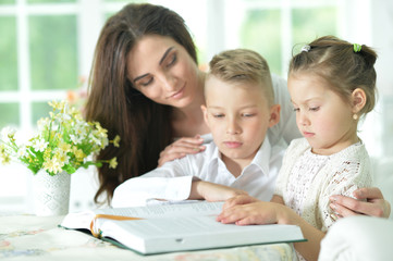 Mother and children reading book