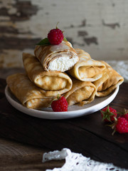 Stuffed pancakes curd with fresh raspberry berries on dark board