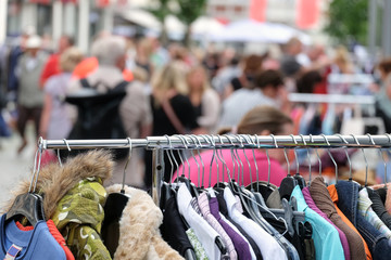Gebrauchte Kleidung auf der Stange auf einem Flohmarkt in der Stadt / Selektive Schärfe für...