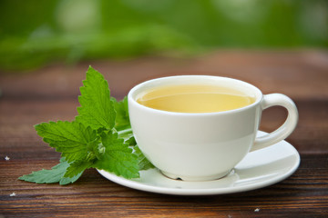porcelainl cup with green tea on table