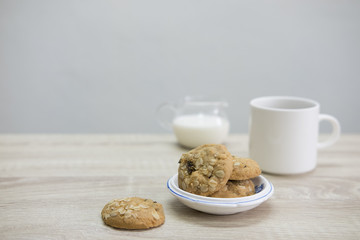 WHITE COFFEE CUP AND COOKIESWhite coffee cup with cookies on the wood table. 