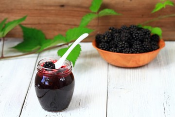 Fototapeta na wymiar Homemade blackberry jam, jar, berries, white wooden table. 