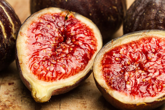 Higos cortados por la mitad en primer plano sobre un fondo de madera r&uacute;stico. Vista de frente y de cerca